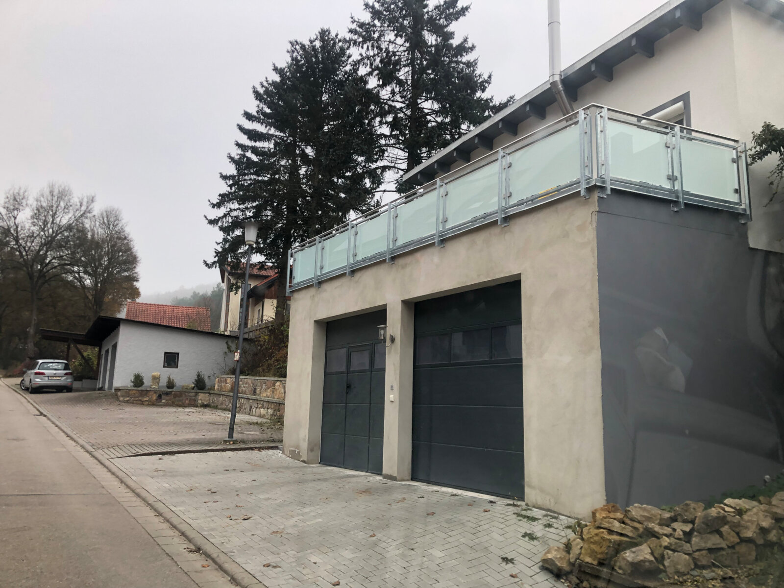 Balkon mit Glasgeländer über Garage